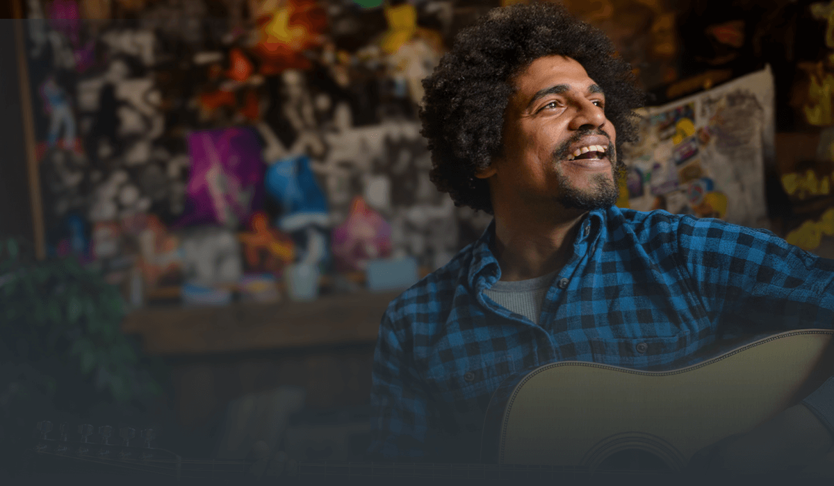 Guitar player enjoying a music session in a colorful indoor setting