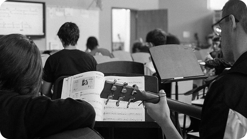 Classroom guitar lesson with students reading music and playing together