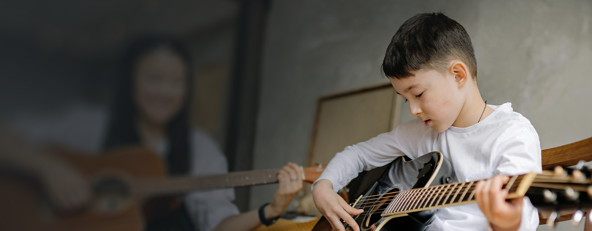 young boy playing acoustic guitar