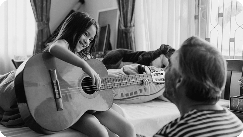 Young student practicing acoustic guitar during an at-home lesson