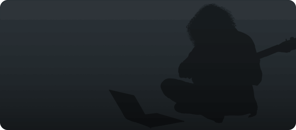 Silhouette of person playing guitar and looking at computer